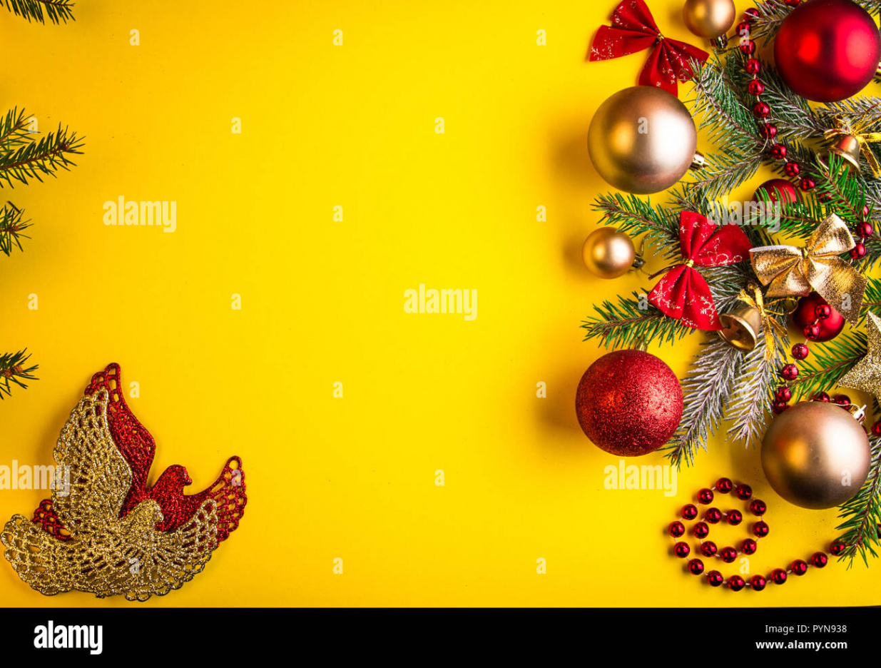 Yellow Christmas background with fir tree, toys and bows Stock